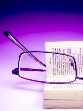 Spectacle on an opened dictionary Stock Photos