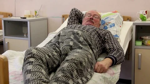 Spectacled old man on nosp bed Video stock 81836104