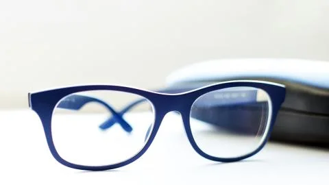 Spectacles and a case on a white table Stock Photos