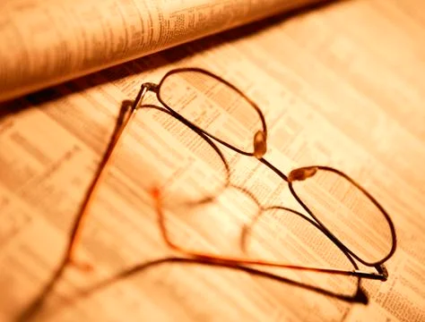 SPECTACLES ON FINANCIAL PAPER Stock Photos