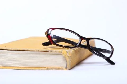 Spectacles lying on old book Stock Photos