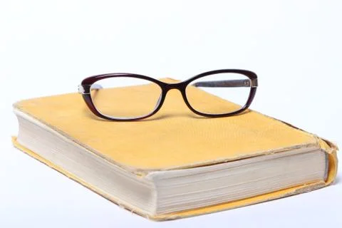 Spectacles lying on old book Stock Photos