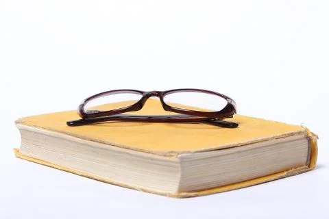 Spectacles lying on old book Stock Photos