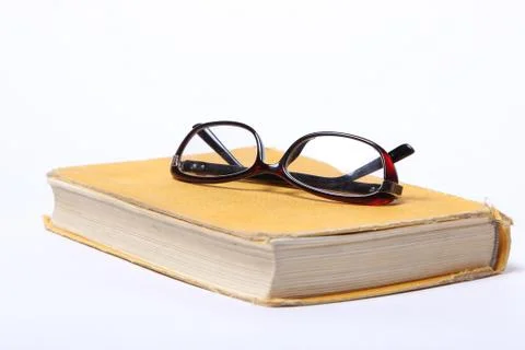 Spectacles lying on old book Stock Photos