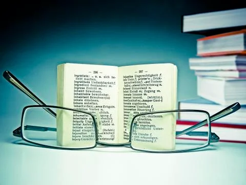 Spectacles on an opened dictionary Stock Photos
