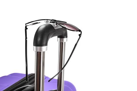 Spectacles on suitcase handle Stock Photos