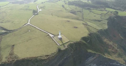Spectacular drone view of a lighthouse on top of high cliffs in Spain Stock Footage 111841555