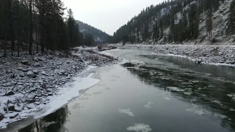 Spectacular Drone view low and fast up Clearwater River Idaho with ice flows Video stock 171779941