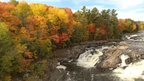 Spectacular fall scene viewed by drone lifting over cascading water Stock Footage 119187759