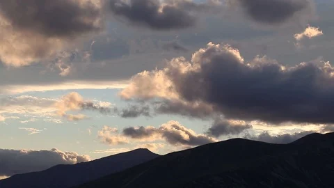 Spectacular fast moving clouds over the mountains. Sunset light. Dramatic atm Stock Footage 91446199