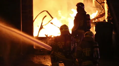 Spectacular house fire, firemen use hose in shadow Stock Footage 53795465
