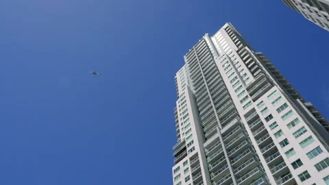 Spectacular low angle view of high contemporary skyscraper connecting with clear Video stock 247328890
