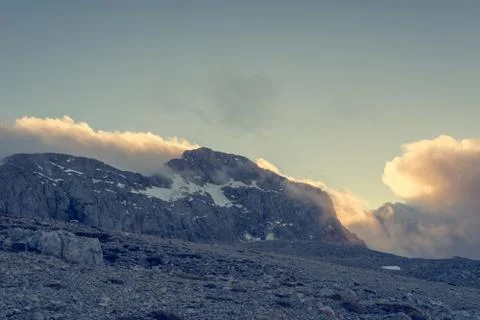 Spectacular mountain view with evening clouds rolling over peaks and ridges. Stock Photos