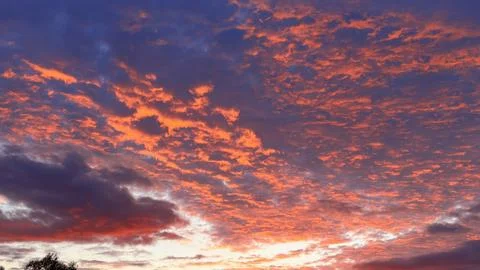 Spectacular panoramic view of a dramatic sunset sky filled with vibrant fiery Stock Photos