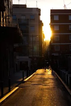 Spectacular sunset with the sun getting between the buildings Stock Photos