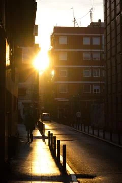 Spectacular sunset with the sun getting between the buildings Stock Photos