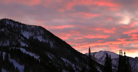 Spectacular sunset view of moving reddish clouds over snow-covered mountains Stock Footage 140828699