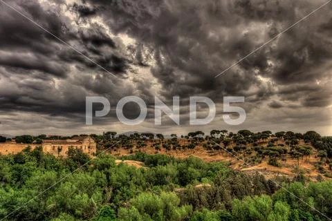 Spectacular view on the hill and greenery with dark, dramatic, stormy clouds Stock Photos