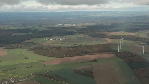 Spectacular view from plane on earth with tiny houses, fields, windmills, woods. Stock Footage 121244375