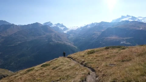 Spectacular view of young man with backpack hiking in the mountains - swiss alps Stock Footage 161270988