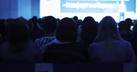 Spectators looking at presentation on screen and listening man speaker on stage. Stock Footage 120134237