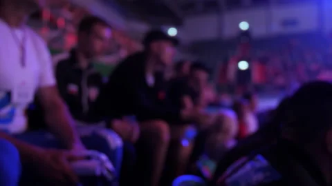 Spectators sit on a trebune. A sporting event in an indoor stadium. Blur content Stock Footage 219855572