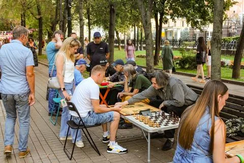 Spectators watching a game of backgammon and chess. 库存照片