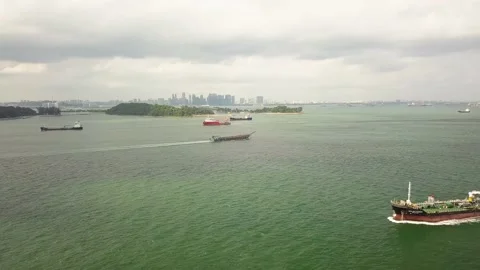 Sped up drone shot of ships sailing Singapore straits with city background Stock Footage 151568320