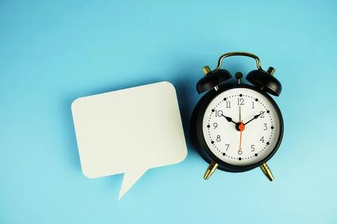 Speech Bubble and alarm clock on blue background Foto stock