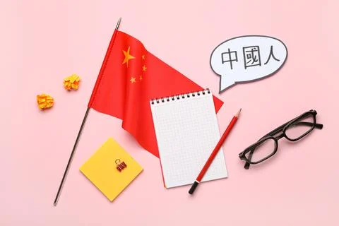 Speech bubble with Chinese text, flag, notebook and eyeglasses on pink backgr Stock Photos