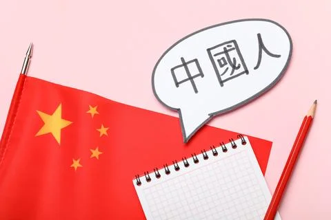 Speech bubble with Chinese text, flag and notebook on pink background Stock Photos