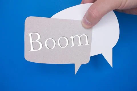 Speech bubble in front of colored background with Boom text. Stock Photos