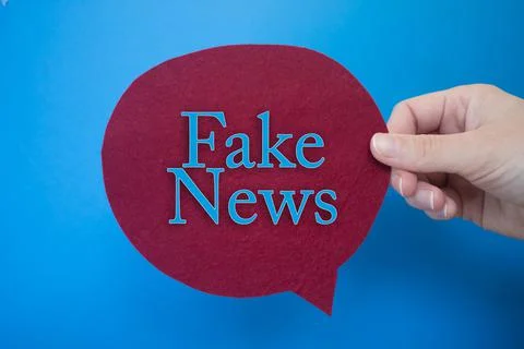 Speech bubble in front of colored background with Fake News text. Stock Photos