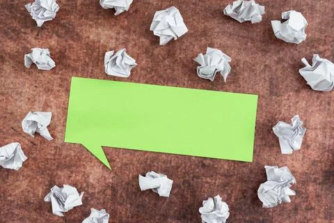 Speech Bubble Made Of Color Sheet Surrounded With Crumpled Papers Over Wooden Stock Photos