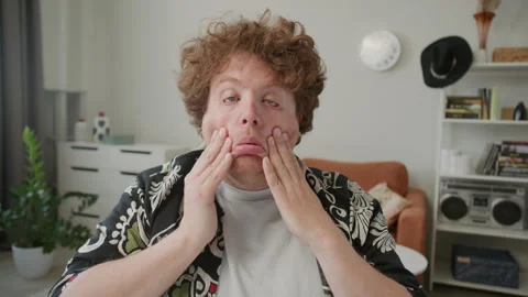 Speech Coach Rubbing Face and Explaining Articulation Technique to Camera Stock Footage 309737708