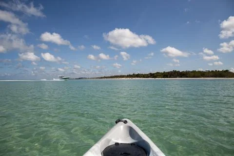 Speed boat in front of Kayak on crystal clear ocean water of Delnor Wiggins S Stock Photos