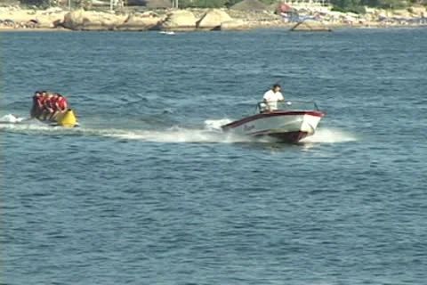 Speed boat pulls kids on an inflatable tube Video stock 9598676