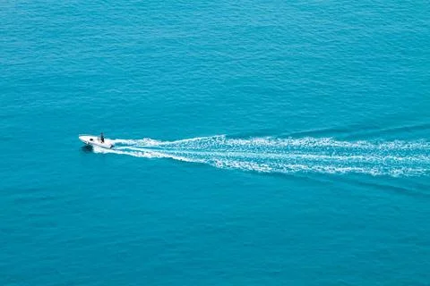 Speed boat quickly floating on the water surface and leaving a trail on the s Stock Photos
