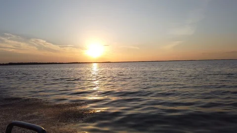 Speed Boat Travelling Quickly Over Water At Sunset With Beautiful Sun And Or Stock Footage 128826426