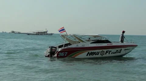 Speed Boat wading with man pulling up anchor Stock Footage 10682613