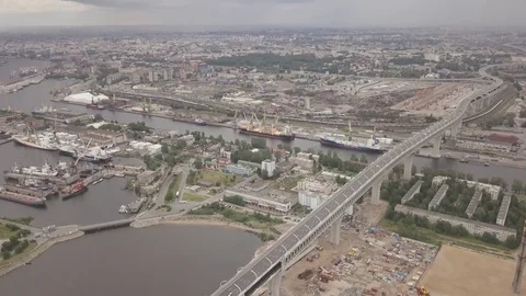 Speed up highway bridge from the sky over the sea port and industrial island Stock Footage