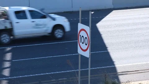 A speed limit sign displaying "100 km/h" at an Australian highway Stock Footage 305976312