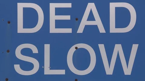 Speed limit sign off highway telling drivers to go dead slow Stock Footage