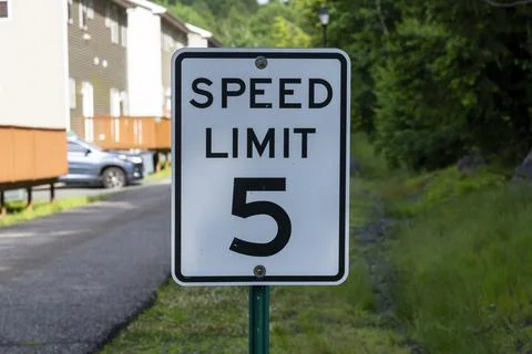 Speed limit sign indicating five miles per hour near residential area Stock Photos