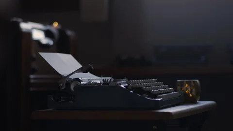 Speed ramps of a man sitting down to write at a vintage typewriter Stock Footage 97846914