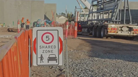 Speed sign on construction site with panel trailer, crane &amp; construction workers Stock Footage 234314628