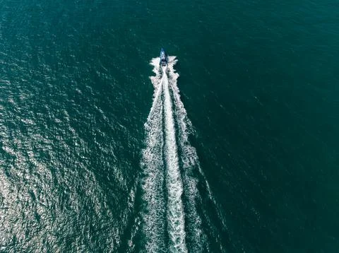Speedboat Navigating Through Open Sea Leaving Foam Trail High Angle Shot Фото
