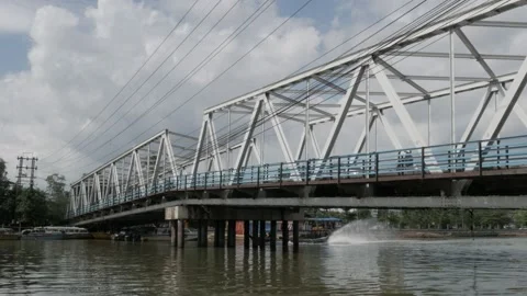 Speedboat passing through under historical Coen-Dewi bridge Stock Footage 136430775