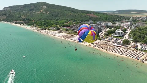 Speedboat pulling a parachute with people moving behind the boat Stock Footage 314782892