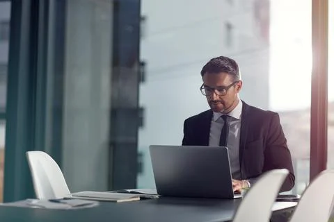 Speeding through work with technology. a businessman working on a laptop in an Stock Photos